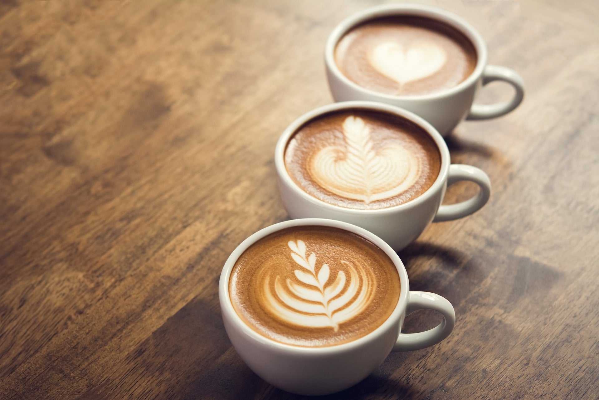 Image of three cups of latte with coffee art